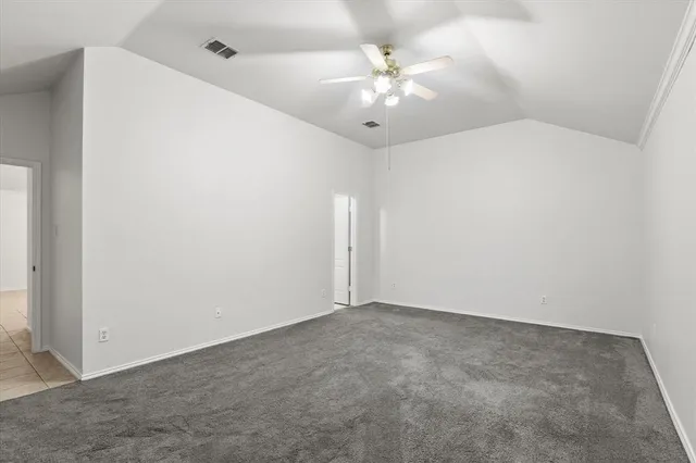 an empty room with chandelier fan