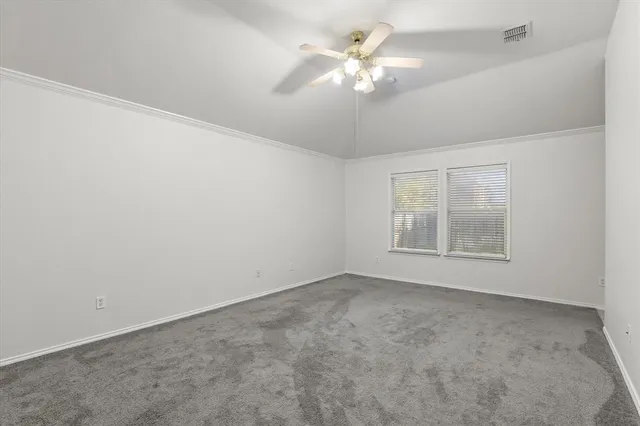 an empty room with a chandelier fan