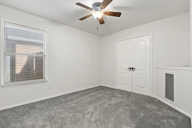 a view of a room with a ceiling fan and a window