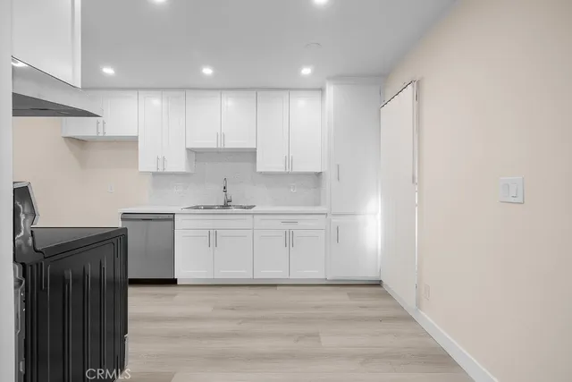 a kitchen with granite countertop white cabinets and stainless steel appliances