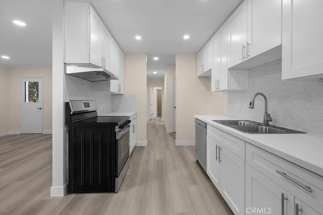 a kitchen with granite countertop a sink and a stove top oven