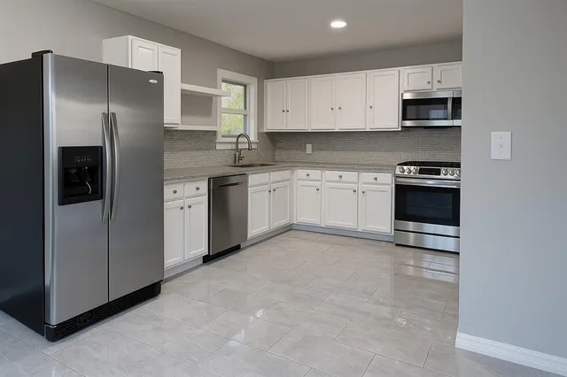 a kitchen with stainless steel appliances granite countertop a refrigerator stove and microwave