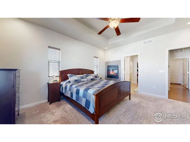 a living room with a bed furniture and a ceiling fan