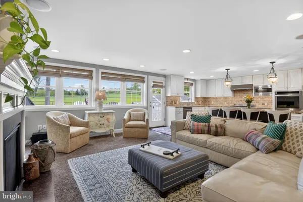 a living room with furniture fireplace and a large window