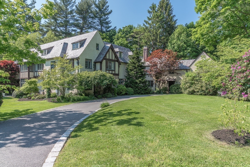 a front view of a house with a yard and trees