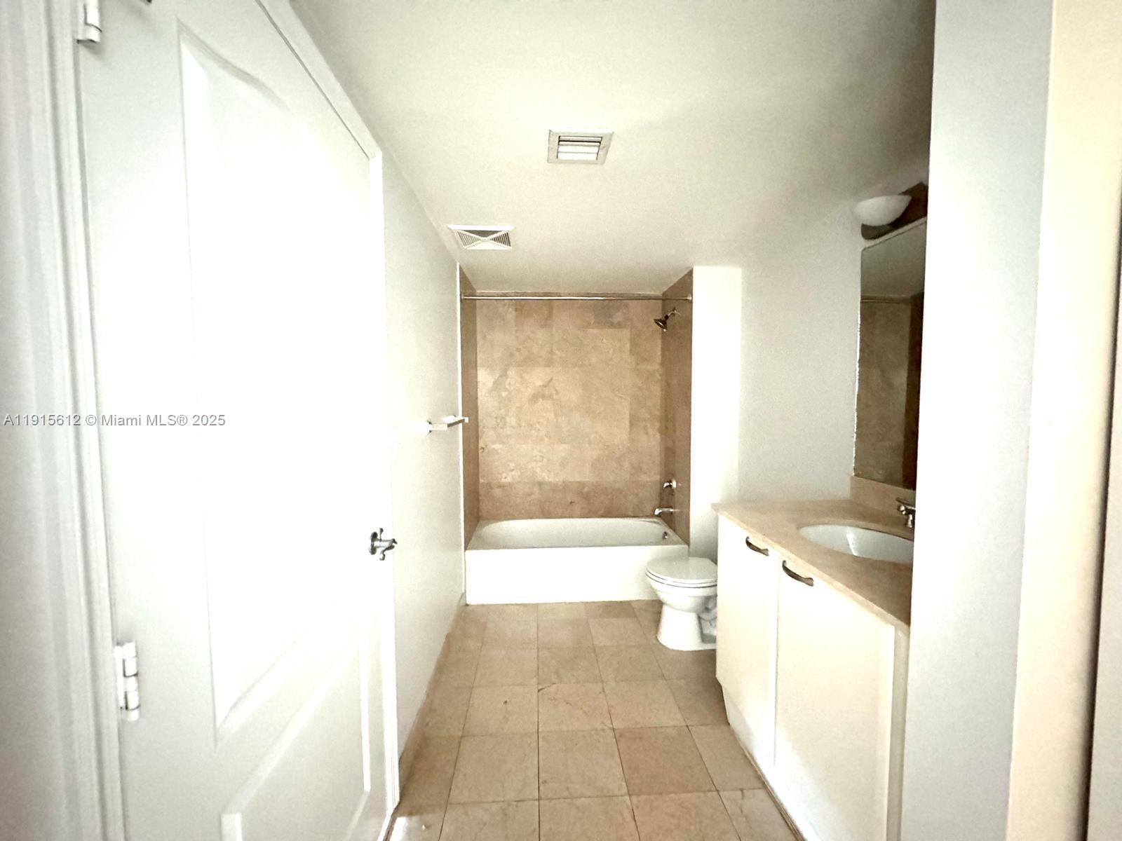 2101 Brickell Avenue, Unit 2411 Miami, FL 33129 - Photo 7 of 10 a bathroom with a granite countertop bathtub shower sink and toilet