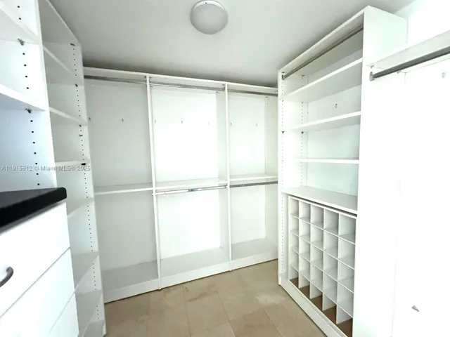 a view of walk in closet with empty racks