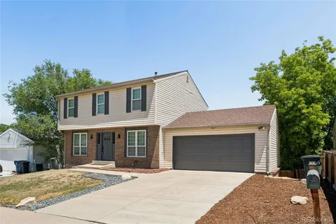 a front view of a house with yard and parking