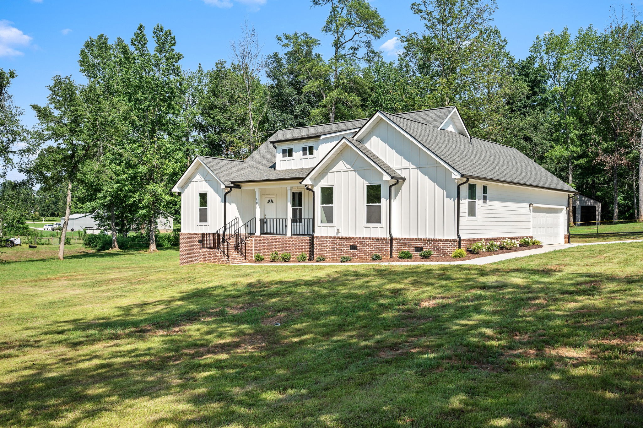 407 Spring Meadows Lane Morrison, TN 37357 - Photo 2 of 25 a view of a white house with a big yard and large trees