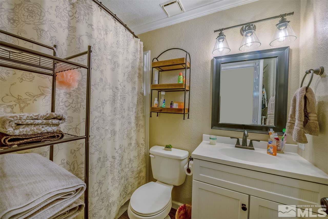 212 Ring Road Dayton, NV 89403 - Photo 8 of 19 a bathroom with a toilet a sink and mirror