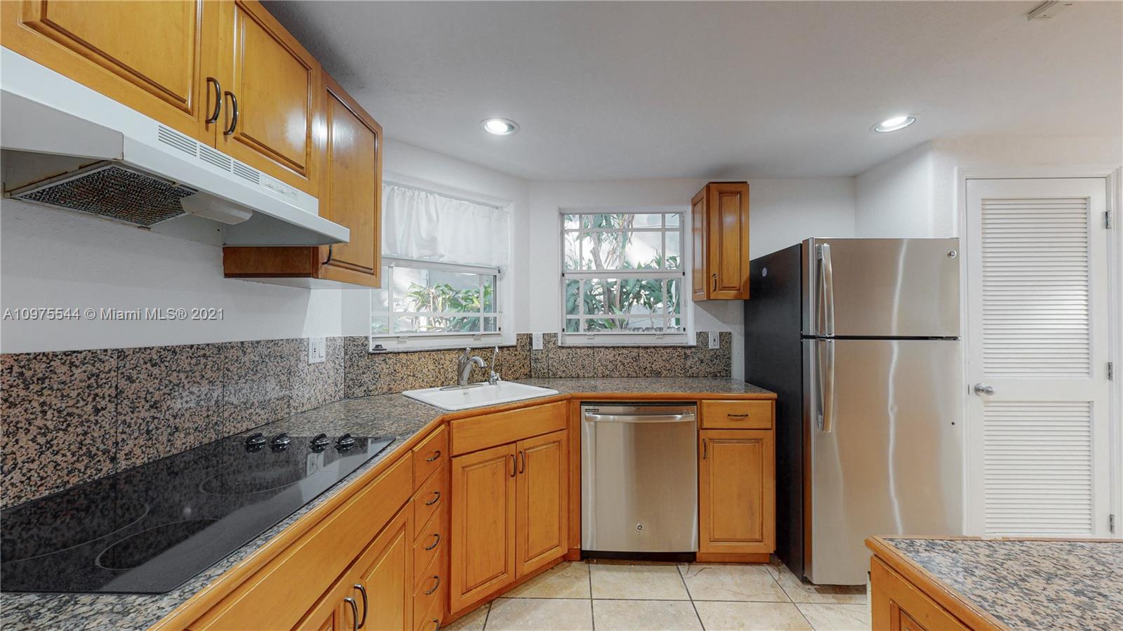 3088 Mary Street, Unit 2 Miami, FL 33133 - Photo 8 of 35 a kitchen with a sink a refrigerator and cabinets