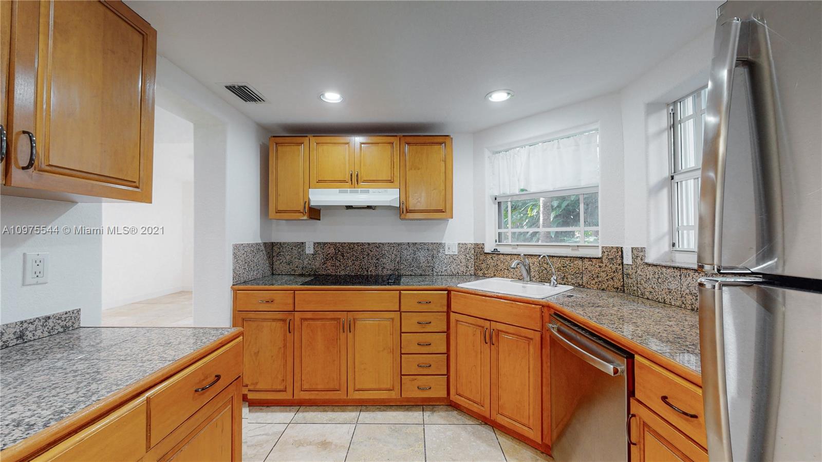 3088 Mary Street, Unit 2 Miami, FL 33133 - Photo 10 of 35 a kitchen with granite countertop kitchen island sink and window