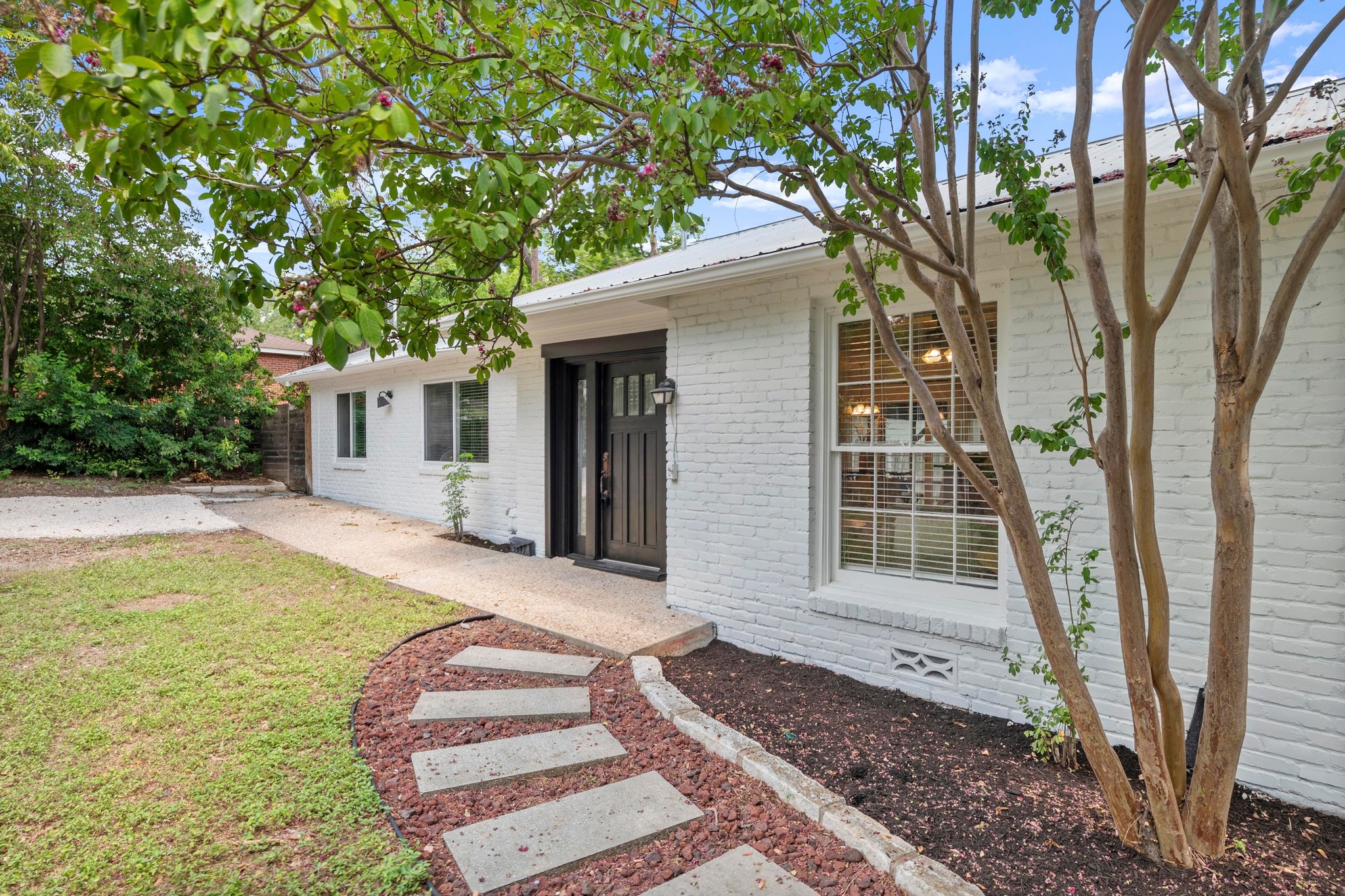 2640 West 45th Street Austin, TX 78731 - Photo 2 of 34 Single story home with a metal roof, brick siding, and a front yard
