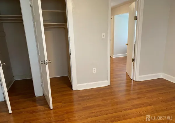 an empty room with wooden floor and entrance
