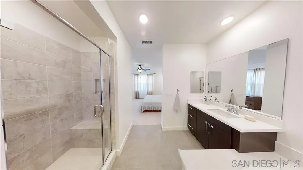 9048 West Bluff Place Santee, CA 92071 - Photo 8 of 14 a large bathroom with a double vanity sink a large mirror and a shower