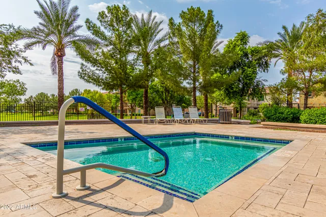 a view of swimming pool with a bench and trees
