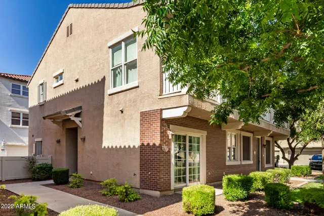a view of a brick house with a large windows and a large tree