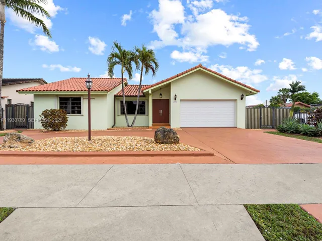 a front view of a house with a yard and potted plants