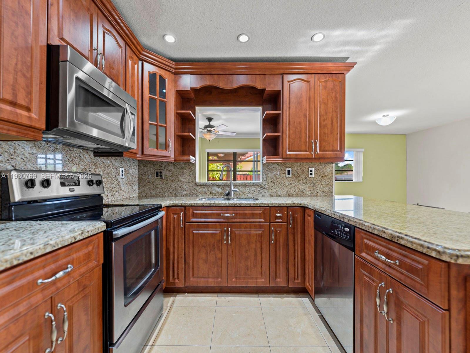 3791 Southwest 142nd Avenue Miami, FL 33175 - Photo 17 of 44 a kitchen with stainless steel appliances granite countertop a sink stove and microwave