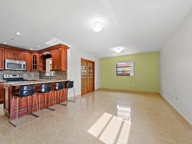 a view of kitchen with stainless steel appliances granite countertop a stove and a sink