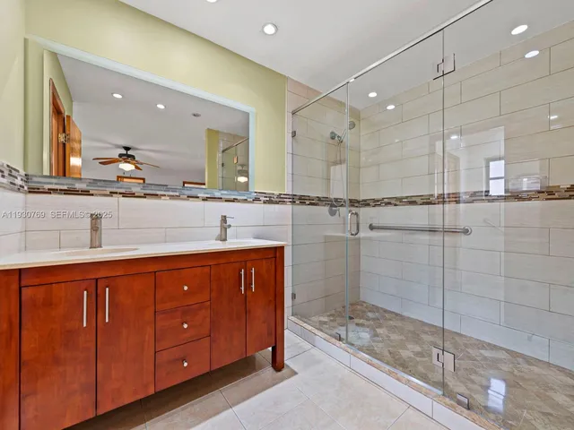 a bathroom with a shower sink and mirror