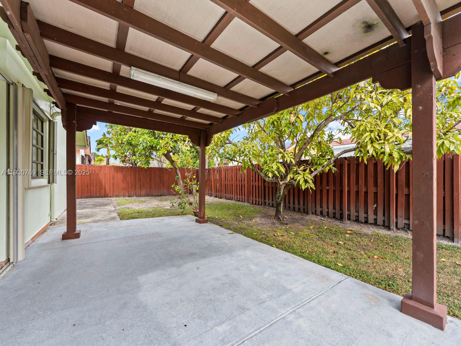 3791 Southwest 142nd Avenue Miami, FL 33175 - Photo 37 of 44 a backyard with wooden fence and a large tree