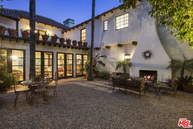 a view of a patio with dining table and chairs under an umbrella