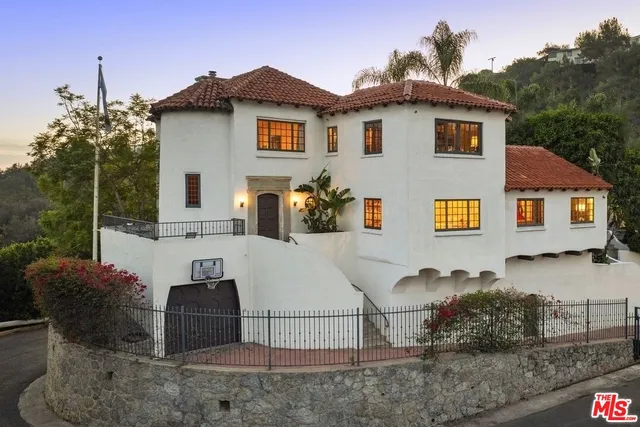 a view of a white house with large windows and a table and chairs
