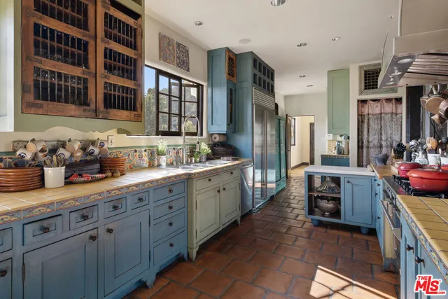 a large kitchen with stainless steel appliances a stove and a sink