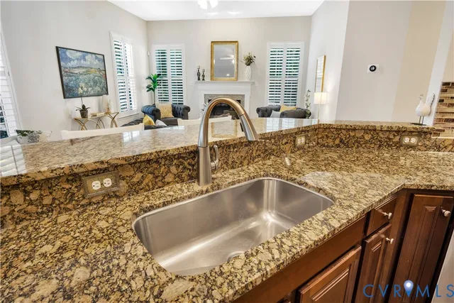 a kitchen with granite countertop a sink stainless steel appliances and cabinets