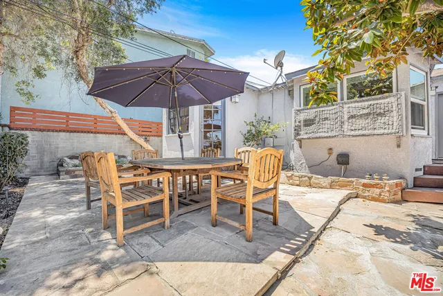 a patio with a table and chairs under an umbrella