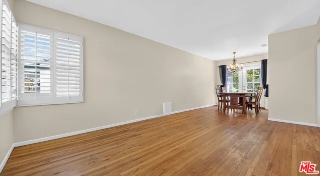 a view of a room with wooden floor fireplace and windows