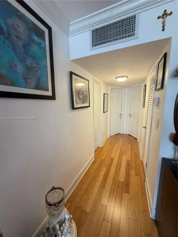 a view of a hallway with wooden floor