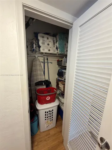 a utility room with closet and mirror