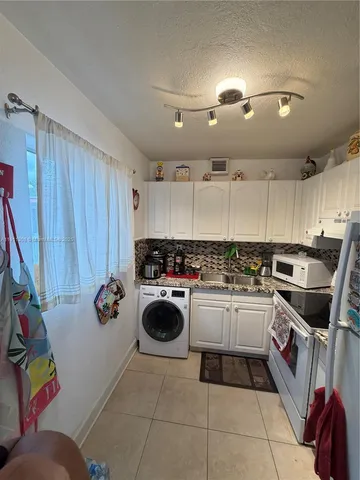 a kitchen with a sink a stove top oven and cabinets