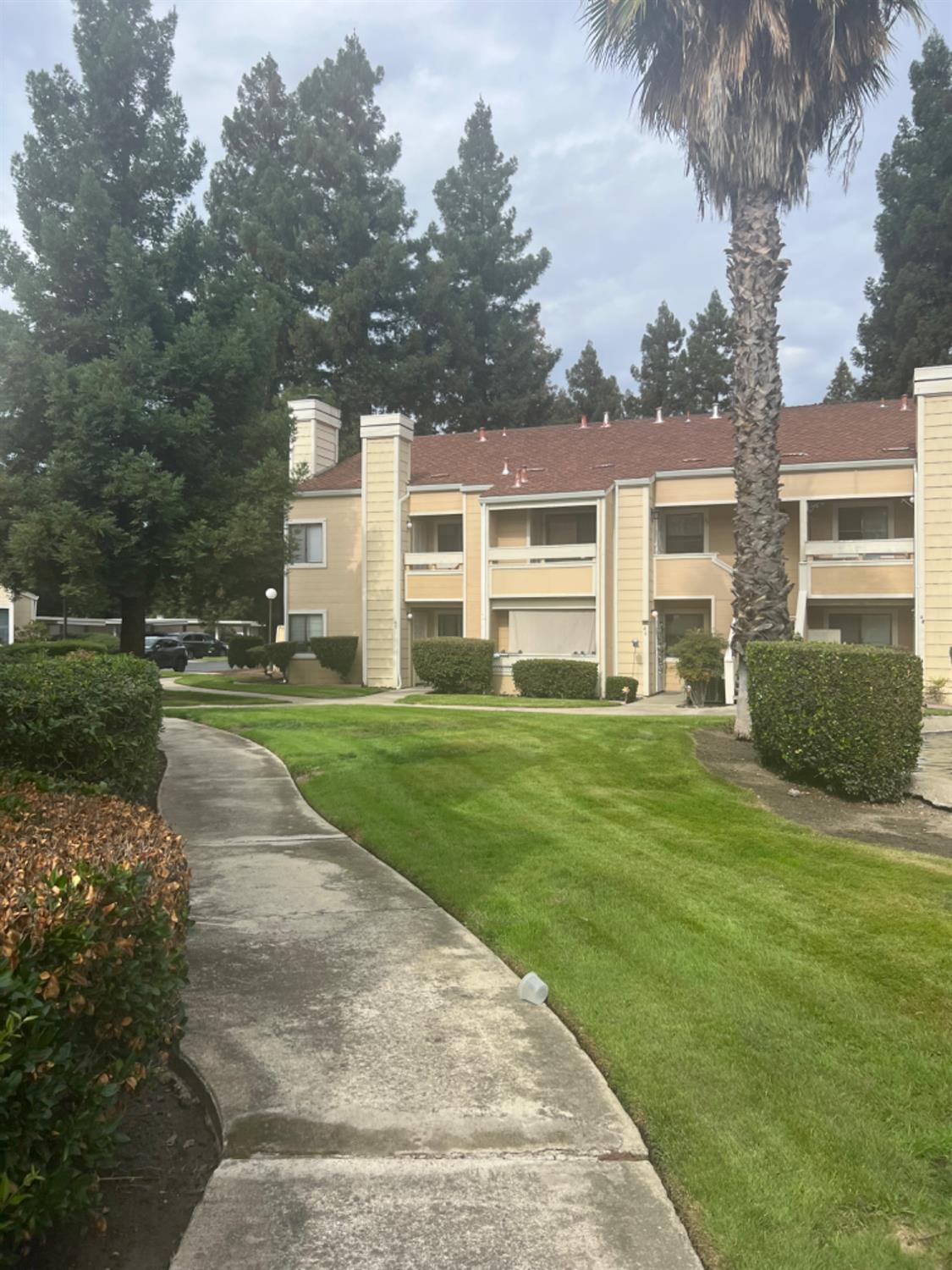 1545 Pyrenees Avenue, Unit 30 Stockton, CA 95210 - Photo 26 of 28 a view of a house with a big yard and large trees