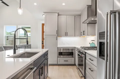 a kitchen with kitchen island a sink stainless steel appliances and cabinets