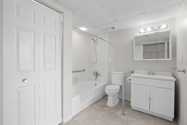a bathroom with a granite countertop toilet a sink and a bathtub