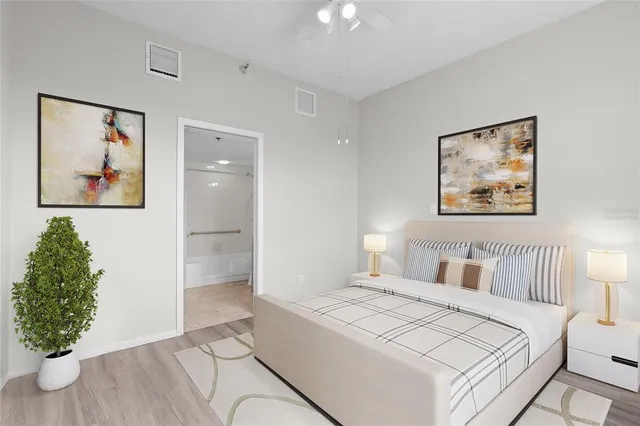 a bedroom with a large bed and a potted plant