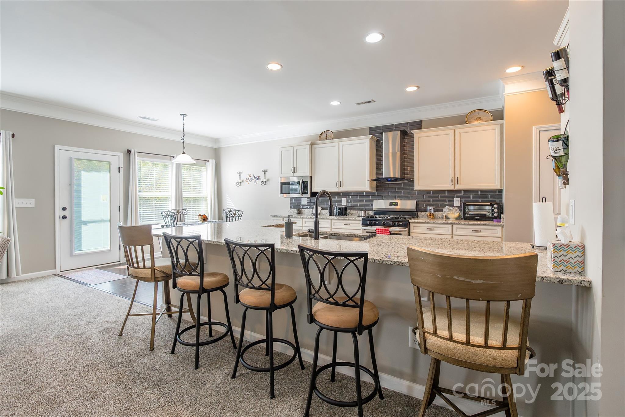 200 Clauser Road South Mount Holly, NC 28120 - Photo 11 of 44 a kitchen with a dining table chairs and white cabinets