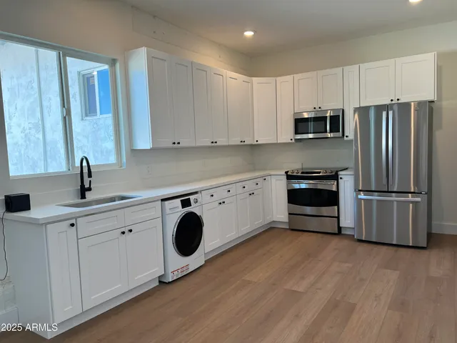 a kitchen with stainless steel appliances and white cabinets