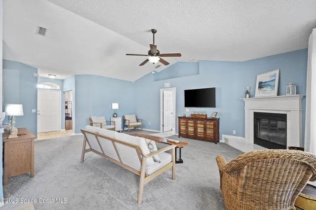 a living room with furniture a fireplace and a flat screen tv