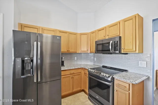 a kitchen with stainless steel appliances granite countertop a sink stove and microwave