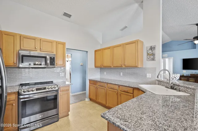 a view of a dining room that has a table and a chandelier
