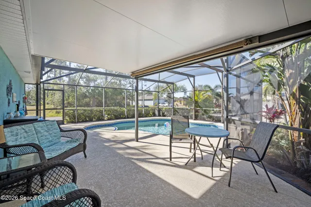 a living room with furniture and a floor to ceiling window