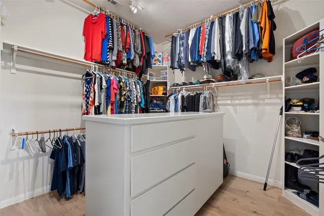 a view of walk in closet with clothes and shoes