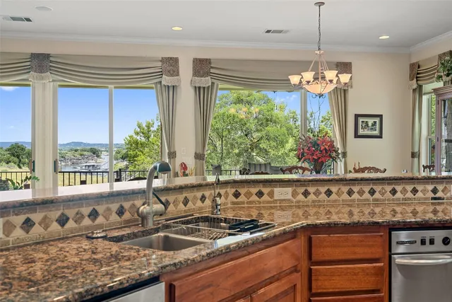 a view of a kitchen island with a large window and chandelier