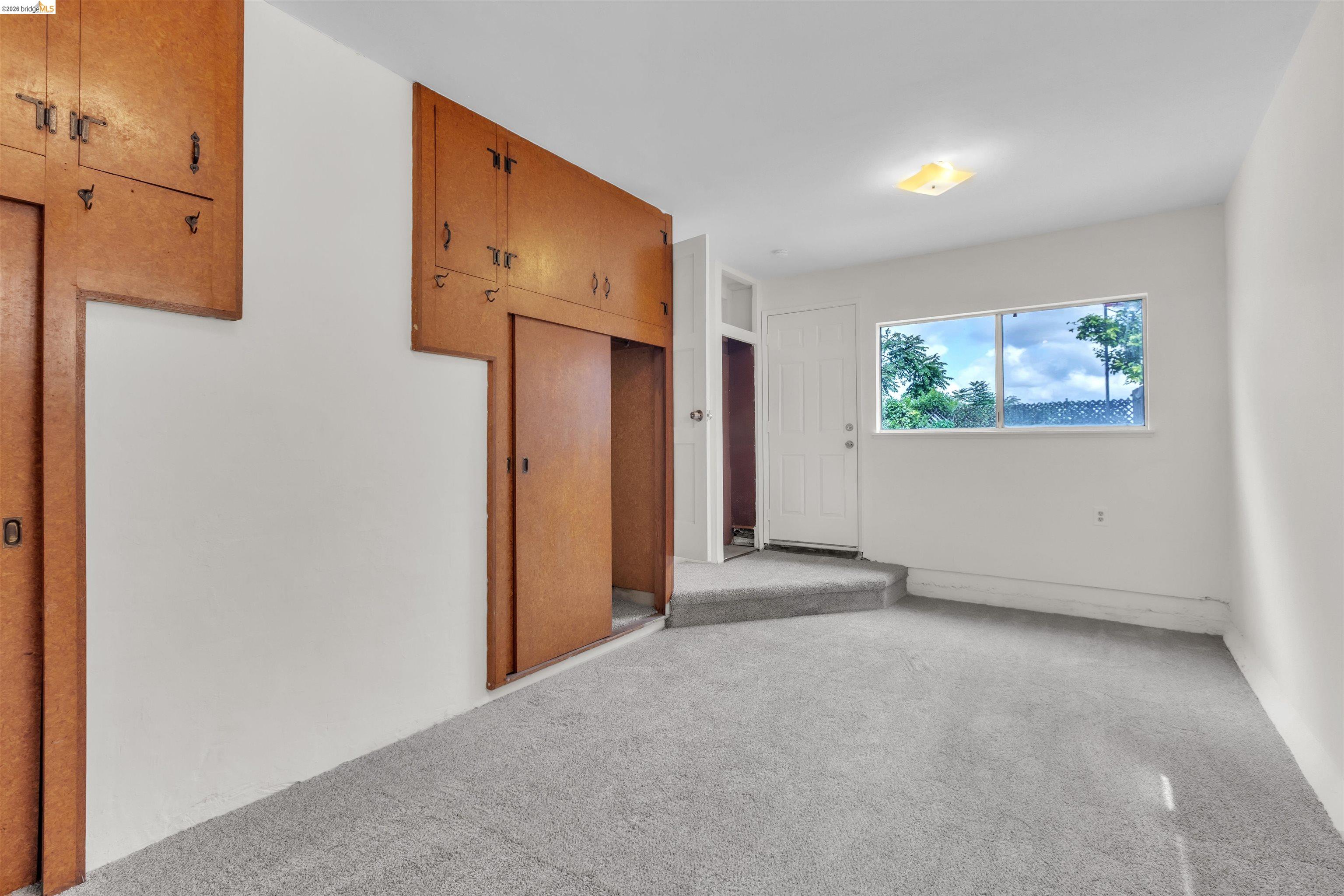 621 Paseo Del Rio San Lorenzo, CA 94580 - Photo 11 of 24 Room featuring light gray carpeting, white walls, and built-in wood-finish cabinetry