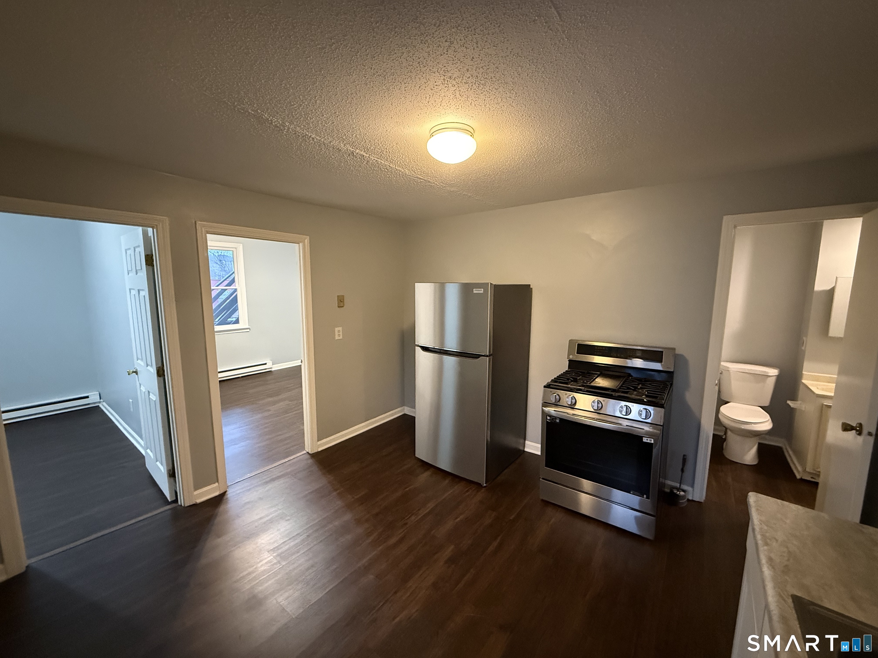 52 Crown Street Naugatuck, CT 06770 - Photo 2 of 11 a view of kitchen with refrigerator stove and wooden floor