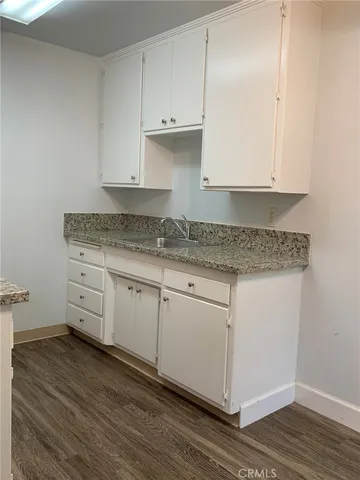 a kitchen with granite countertop white cabinets and white appliances